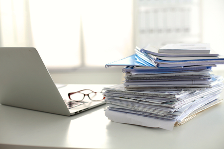 office desk a stack of computer paper reports work forms.の写真素材