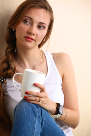 Young woman at home sipping tea from a cup.の写真素材