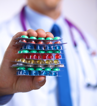 Hand of doctors holding many different pills.の写真素材