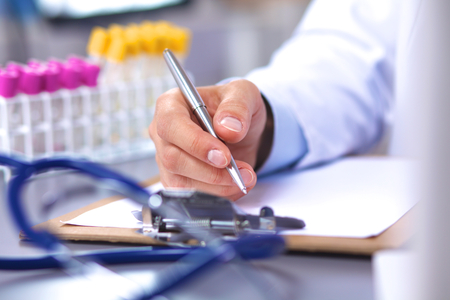 doctor at his desk working with medical equipment in the background.の写真素材