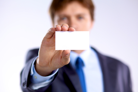 young businessman holds out his hand with a business card.の写真素材