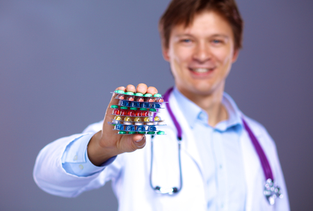 A young doctor holds the patient's hand with pills.の写真素材
