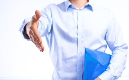 businessman with papers holds out his hand for a handshake.の写真素材