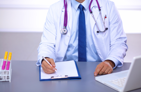 Male medicine doctor hands hold jar of pills and type something on laptop computer keyboard. Panacea and life save, prescribing treatment, legal drug store, take stock, consumption statistics concept.の写真素材