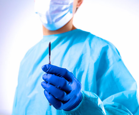 Man surgeon holds a scalpel in an operating room .