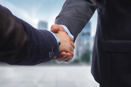 Business handshake. Two businessman shaking hands with each other in the office.の写真素材