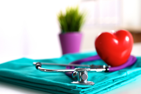 stethoscope shaping heart and clipboard on medical uniform, closeupの写真素材