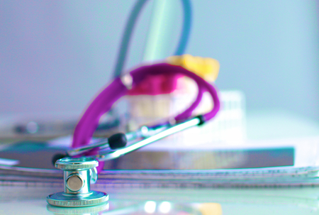 A medical stethoscope near a laptop on table, on whiteの写真素材