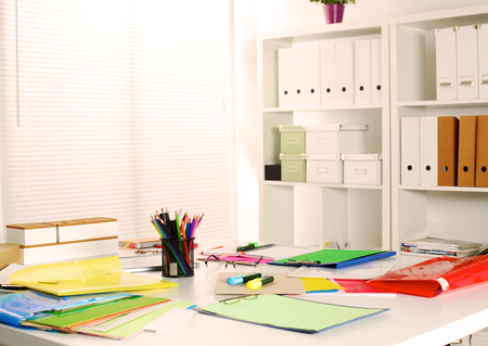 Designer working desk with computer and paperworkの写真素材