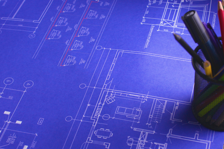 Architectural blueprints and blueprint rolls and a drawing instruments on the worktableの写真素材