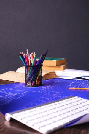 Architectural blueprints and blueprint rolls and a drawing instruments on the worktableの写真素材