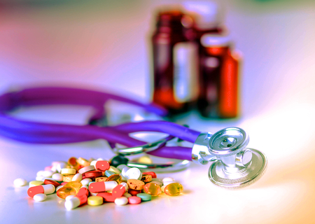 Stethoscope and some pills - isolated on a white backgroundの写真素材