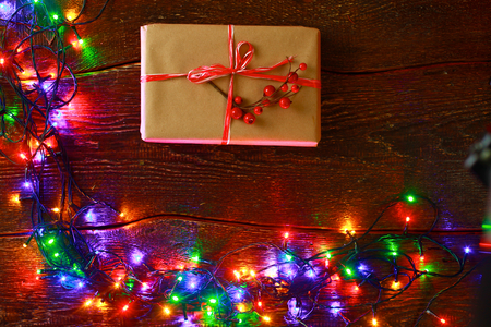 Christmas gift or present box wrapped in kraft paper with decoration on rustic wooden backgroundの写真素材