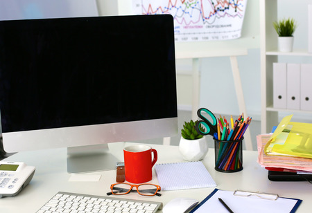 Office table with blank notepad and laptopの写真素材