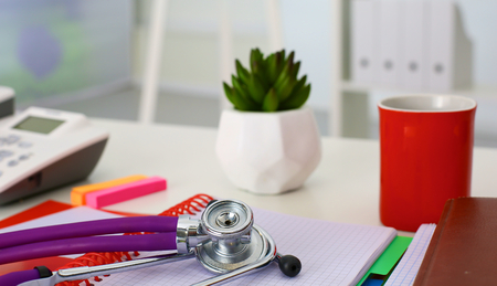 Medical stethoscope and a plate on the tableの写真素材