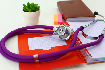 Medical stethoscope and a plate on the tableの写真素材
