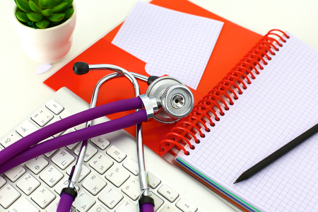 Medical stethoscope and a plate on the tableの写真素材
