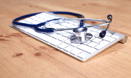 Tablet computer with a stethoscope lie on a tableの写真素材