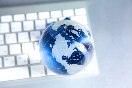 Cristal globe of the Earth on a Computerの写真素材