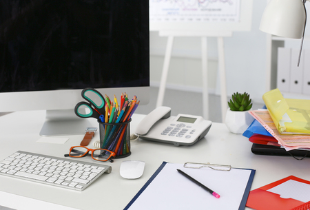 Office table with blank notepad and laptopの写真素材