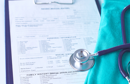 A stethoscope shaping a heart and a clipboard on a medical uniform, closeupの写真素材