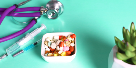 medical stethoscope with pills isolated on white backgroundの写真素材