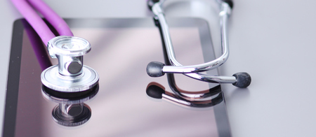 Stethoscope with a tablet computer lie on a tableの写真素材