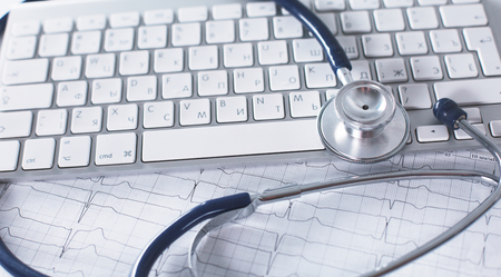 A stethoscope is on the keyboard of a computerの写真素材