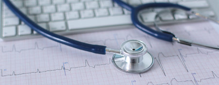 Stethoscope on cardiogram concept for heart care on the desk.blue toned images