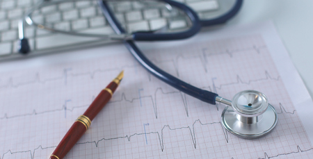 Stethoscope on cardiogram concept for heart care on the desk.blue toned imagesの写真素材