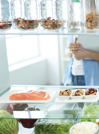 Happy Woman With Vegetables In Front Of Open Refrigerator.の写真素材