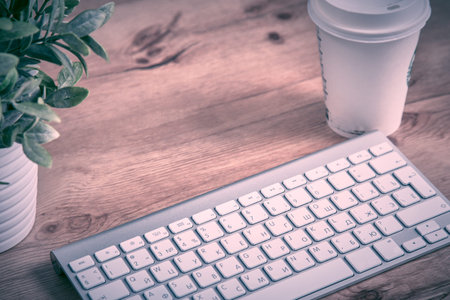 Modern aluminum keyboard on the wooden table in the officeの写真素材