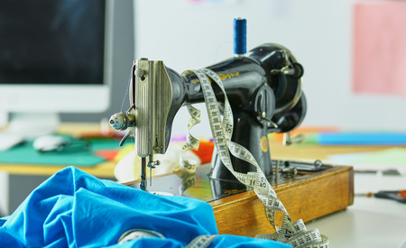 Retro sewing machine on designer clothes desktopの写真素材