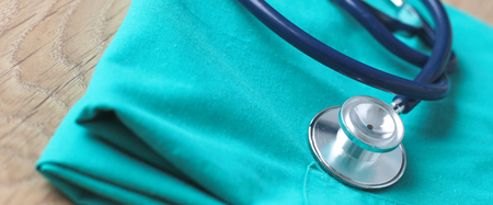 A stethoscope shaping a heart on a medical uniform, closeup, selective focusの写真素材
