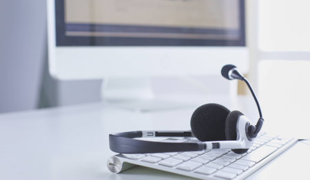 Communication support, call center and customer service help desk. VOIP headset on laptop computer keyboardの写真素材