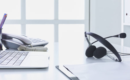 Communication support, call center and customer service help desk. VOIP headset on laptop computer keyboardの写真素材