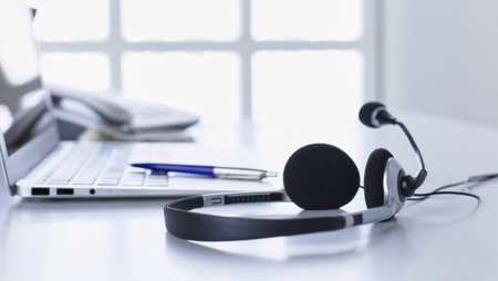 Communication support, call center and customer service help desk. VOIP headset on laptop computer keyboardの写真素材