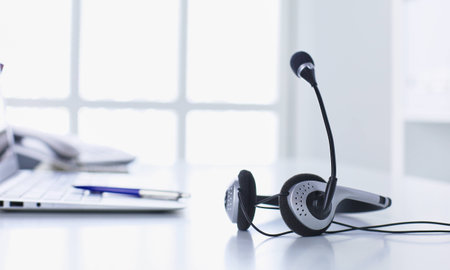 Communication support, call center and customer service help desk. VOIP headset on laptop computer keyboardの写真素材