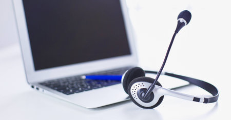 Communication support, call center and customer service help desk. VOIP headset on laptop computer keyboardの写真素材