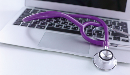 Stethoscope lying on a laptop keyboard in a concept of online medicine or troubleshooting the computer viewed low angle with copy spaceの写真素材