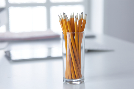 Graphite pencils in a glass cup on the office table. Conceptの写真素材