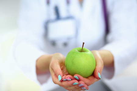 Doctor holding fresh green apples, closeup shot.の写真素材