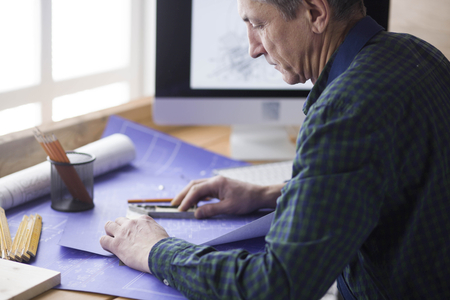 Engineer carpenter working on laptop and sketching projectの写真素材