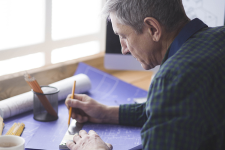 Engineer carpenter working on laptop and sketching projectの写真素材