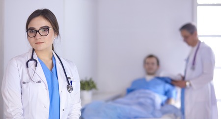 Doctor checking heart beat of patient in bed with stethoscopeの写真素材