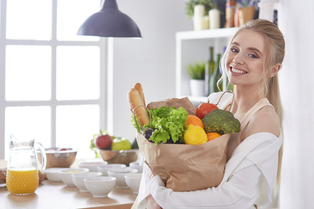 Young woman holding grocery shopping bag with vegetables Standiの写真素材