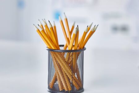 Graphite pencils in a glass cup on the office table. Concept.の写真素材