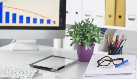 Stylish workspace with desktop computer, office supplies, houseplant and books at office. desk work concept.の写真素材