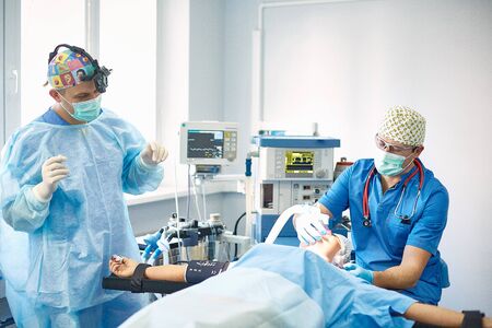 Several doctors surrounding patient on operation table during tの写真素材