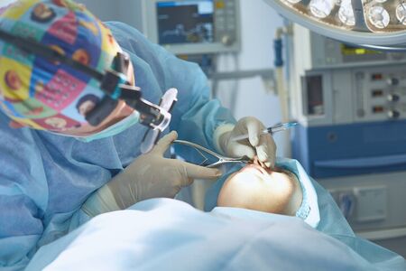 Several doctors surrounding patient on operation table during tの写真素材
